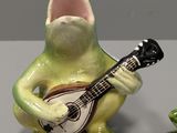 three figurines of a frog playing a guitar and a frog playing a guitar