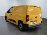 the yellow van is parked in the large room of the building