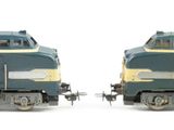 two trains that are sitting side by side on a white surface