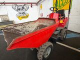 a red tractor with a red trailer parked in a garage