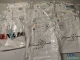 six paires de pantalons blancs sont emballées dans des sacs en plastique sur une table