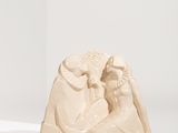 sculpture représentant un homme et une femme assis sur un socle blanc