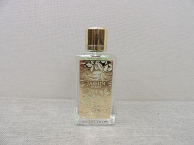 une image représentant un flacon de parfum posé sur une surface blanche