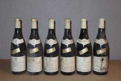 six bouteilles de vin sont alignées sur une table