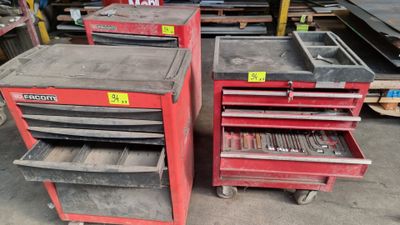 deux chariots à outils rouges, chargés d'outils, dans un entrepôt