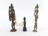 trois figurines en bronze représentant des personnages africains sur fond blanc