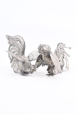 pair of silver rooster figurines on white background with white background