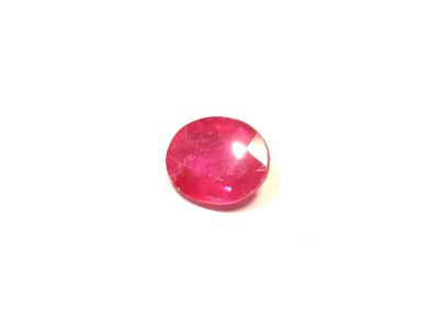 gros plan d'une pierre de rubis rouge sur une surface blanche
