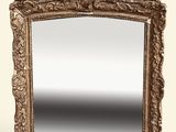 On voit un miroir richement sculpté sur fond blanc.