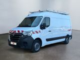La camionnette blanche est garée dans une grande pièce ; elle porte une bande rouge et blanche sur le côté.