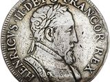 une pièce d'argent sur laquelle figurent le visage d'un homme et une couronne