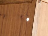 a close up of a wooden cabinet with a hole in it