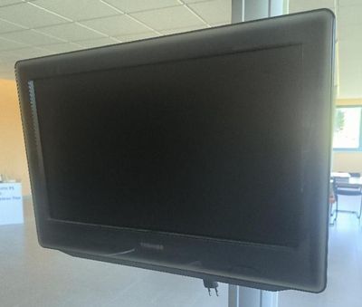 a flat screen tv mounted on a pole in a room