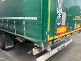 un gros camion vert garé sur un parking