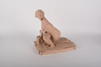 une petite statue représentant un garçon assis sur un rocher