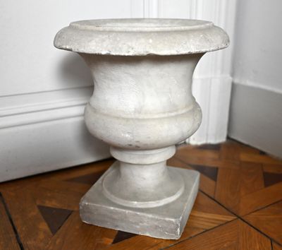 un vase blanc posé par terre dans un coin de la pièce