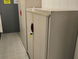 two refrigerators in the hallway of a public restroom