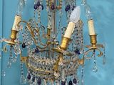 a chandelier hanging from a blue wall in a room