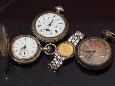 four different types of pocket watches sitting on a table