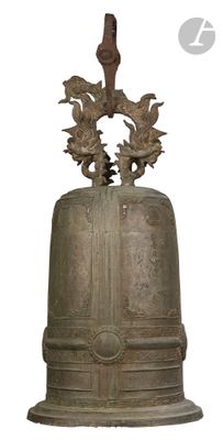 une grande cloche en métal surmontée d'un oiseau
