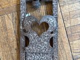 a metal object on the floor with a heart cut out of it