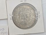 two silver coins sitting next to each other on top of a piece of paper