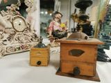 Plusieurs figurines sont posées sur une table où se trouvent également une horloge et une boîte