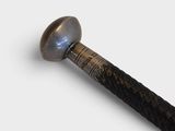a close up of a metal object with a black handle
