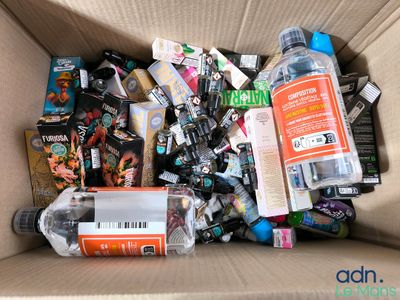 a cardboard box filled with assorted items and a bottle