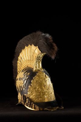 an image of a gold helmet with feathers on a black background