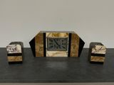 une horloge posée sur une table, à côté de deux blocs