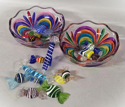 two glass bowls with candy in them sitting on a table