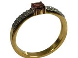 gros plan d'une bague en or avec une pierre rouge