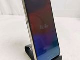 the back of a black and silver phone on a stand on a white surface