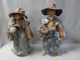 two figurines of a woman and a man holding flowers