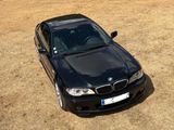 a black car that is parked in a field