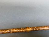 a wooden stick with a design on it sitting on a table