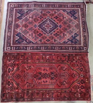 deux tapis exposés dans une pièce, à côté d'un miroir