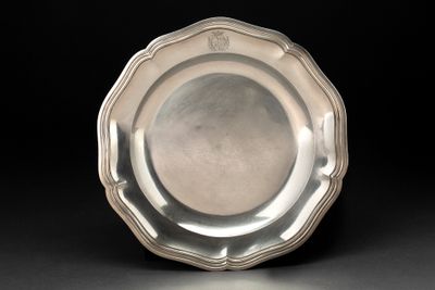 une assiette ancienne en argent sur fond noir, avec un fond noir