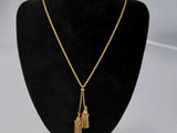 un collier en or orné d'un pompon, suspendu à un mannequin