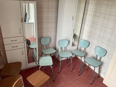 five chairs in a room with a mirror on the wall