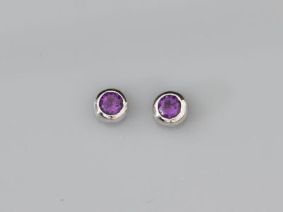 une paire de boucles d'oreilles en améthorate sur fond blanc