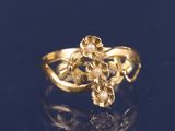 a close up of a gold ring with pearls on a black surface