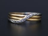 a close up of a gold and silver ring on a black surface