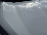 the hood of a white car with a sky in the background