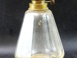 an old fashioned oil lamp with a glass shade on a black background