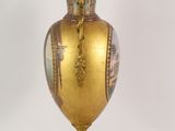 a gold vase that is sitting on a stand