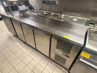 plan de travail en acier inoxydable dans une cuisine professionnelle équipée de trois éviers