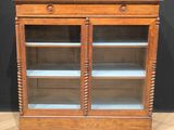 an old wooden display cabinet with glass doors and shelves