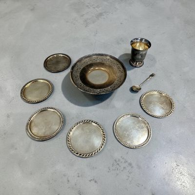 Plusieurs plats et cuillères en argent sont disposés sur une table